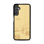 Coque de protection en bois véritable fabriquée en France pour  sur le thème de la montagne, du ski et de la neige avec un motif représentant une paire de ski plantée dans la neige avec en fond des montagnes enneigées