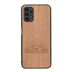 Coque de protection en bois véritable fabriquée en France pour Samsung A13 sur le thème chill et nature avec un motif représentant un levé de soleil sur un paysage de montagne avec des sapins et un chalet et la phrase "Good friends, good adventure"
