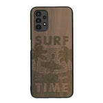 Coque de protection en bois véritable fabriquée en France pour Samsung A13 sur le thème chill avec un motif représentant une silouhette tenant une planche de surf sur une plage entouré de palmiers et les mots "Surf Time Long Beach Miami"