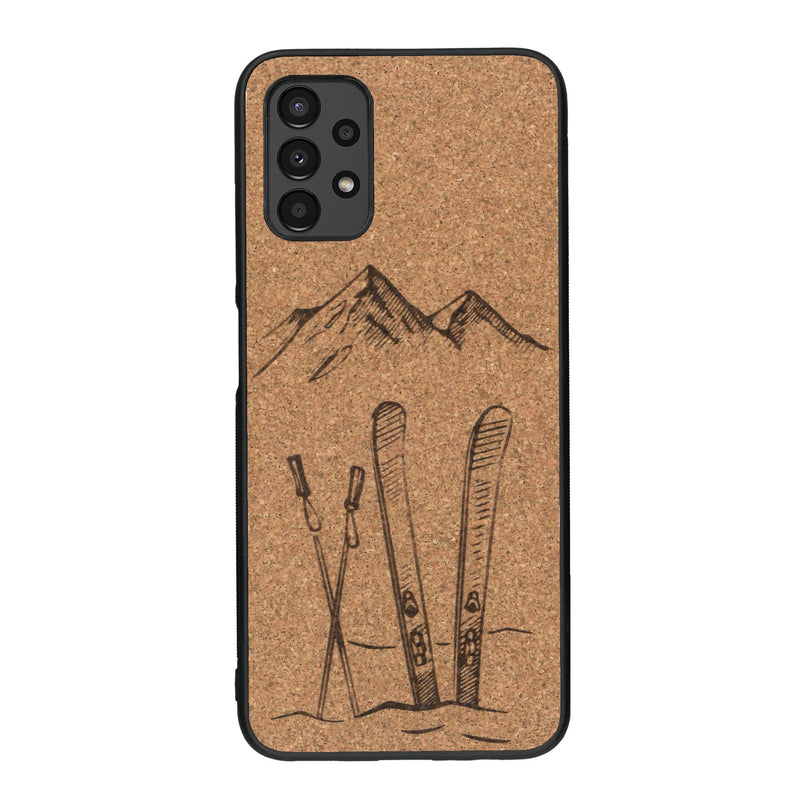 Coque de protection en bois véritable fabriquée en France pour Samsung A13 sur le thème de la montagne, du ski et de la neige avec un motif représentant une paire de ski plantée dans la neige avec en fond des montagnes enneigées