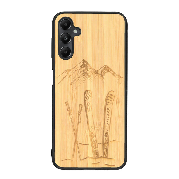 Coque de protection en bois véritable fabriquée en France pour Samsung A15 sur le thème de la montagne, du ski et de la neige avec un motif représentant une paire de ski plantée dans la neige avec en fond des montagnes enneigées