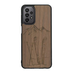 Coque de protection en bois véritable fabriquée en France pour Samsung A23 sur le thème de la montagne, du ski et de la neige avec un motif représentant une paire de ski plantée dans la neige avec en fond des montagnes enneigées