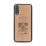 Coque de protection en bois véritable fabriquée en France pour  sur le thème de la nature et des arbres avec une gravure représentant une pomme de pin et la phrase "made by nature"