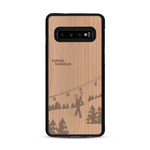 Coque de protection en bois véritable fabriquée en France pour  sur le thème de la montagne, du ski et de la neige avec un motif représentant une paire de ski plantée dans la neige avec en fond des montagnes enneigées