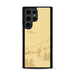 Coque de protection en bois véritable fabriquée en France pour  sur le thème de la montagne, du ski et de la neige avec un motif représentant une paire de ski plantée dans la neige avec en fond des montagnes enneigées