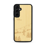 Coque de protection en bois véritable fabriquée en France pour  sur le thème de la montagne, du ski et de la neige avec un motif représentant une paire de ski plantée dans la neige avec en fond des montagnes enneigées
