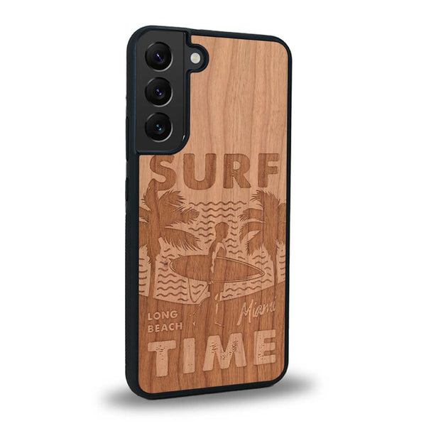 Coque de protection en bois véritable fabriquée en France pour Samsung S24 sur le thème chill avec un motif représentant une silouhette tenant une planche de surf sur une plage entouré de palmiers et les mots "Surf Time Long Beach Miami"
