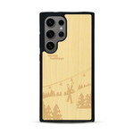 Coque de protection en bois véritable fabriquée en France pour  sur le thème de la montagne, du ski et de la neige avec un motif représentant une paire de ski plantée dans la neige avec en fond des montagnes enneigées