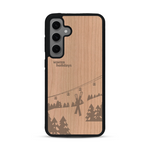 Coque de protection en bois véritable fabriquée en France pour  sur le thème de la montagne, du ski et de la neige avec un motif représentant une paire de ski plantée dans la neige avec en fond des montagnes enneigées