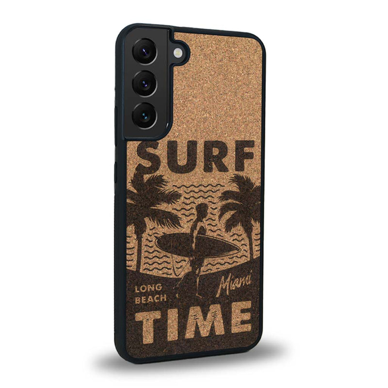 Coque de protection en bois véritable fabriquée en France pour Samsung S24+ sur le thème chill avec un motif représentant une silouhette tenant une planche de surf sur une plage entouré de palmiers et les mots "Surf Time Long Beach Miami"