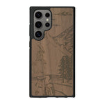 Coque de protection en bois véritable fabriquée en France pour Samsung S25 Ultra sur le thème de la randonnée en montagne et de l'aventure avec une gravure représentant une femme de dos face à un paysage de nature