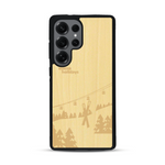 Coque de protection en bois véritable fabriquée en France pour  sur le thème de la montagne, du ski et de la neige avec un motif représentant une paire de ski plantée dans la neige avec en fond des montagnes enneigées