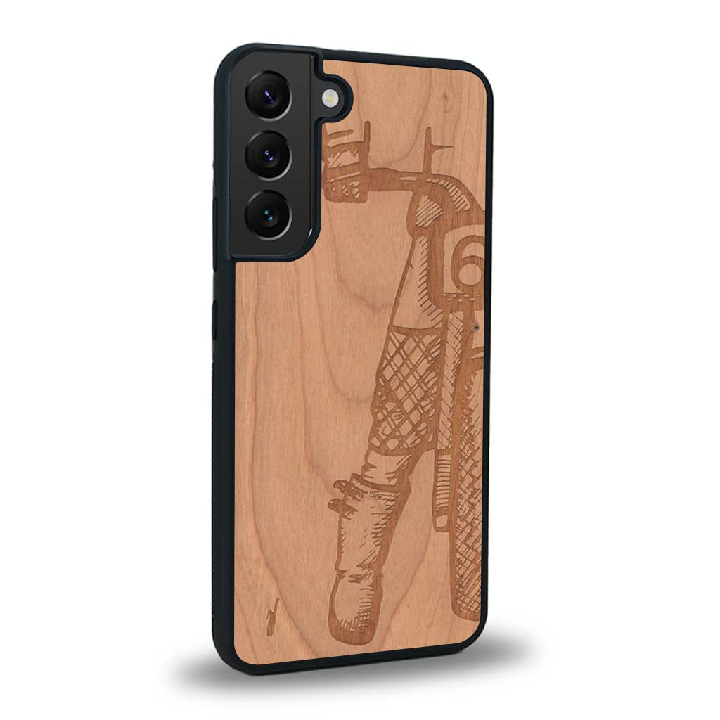 Coque de protection en bois véritable fabriquée en France pour Samsung S25+ représentant une vue de face d'une femme sur une moto vintage dessinée à la main par l'artiste Maud Dabs