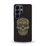 Coque de protection en bois véritable fabriquée en France pour Samsung S26 Ultra alliant du chêne fumé avec du métal argenté et doré représentant une tête de mort mexicaine sur le thème Dia de los Muertos