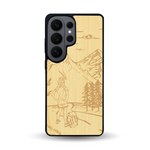Coque de protection en bois véritable fabriquée en France pour Samsung S26 Ultra sur le thème de la randonnée en montagne et de l'aventure avec une gravure représentant une femme de dos face à un paysage de nature