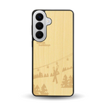 Coque de protection en bois véritable fabriquée en France pour  sur le thème de la montagne, du ski et de la neige avec un motif représentant une paire de ski plantée dans la neige avec en fond des montagnes enneigées