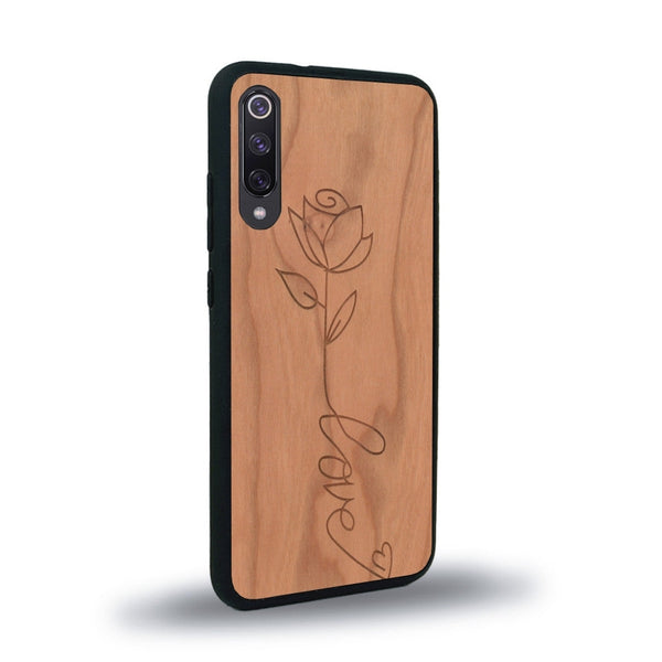 Coque de protection en bois véritable fabriquée en France pour Xiaomi Mi 9SE sur le thème de la fête des mères avec un motif représentant une fleur dont la tige forme le mot "love"
