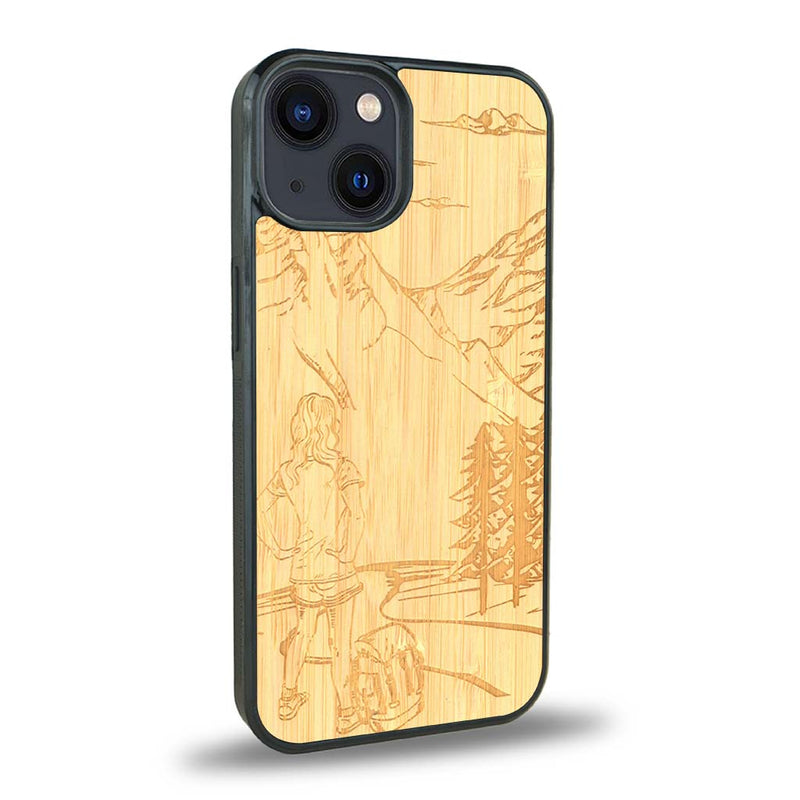 Coque de protection en bois véritable fabriquée en France pour iPhone 15 sur le thème de la randonnée en montagne et de l'aventure avec une gravure représentant une femme de dos face à un paysage de nature