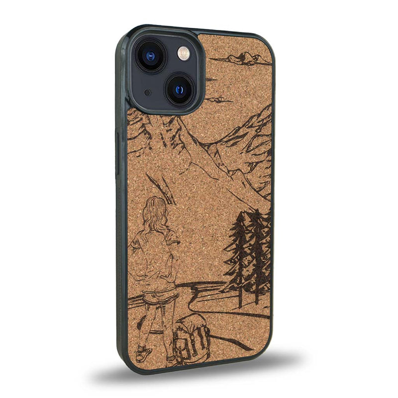 Coque de protection en bois véritable fabriquée en France pour iPhone 15 sur le thème de la randonnée en montagne et de l'aventure avec une gravure représentant une femme de dos face à un paysage de nature