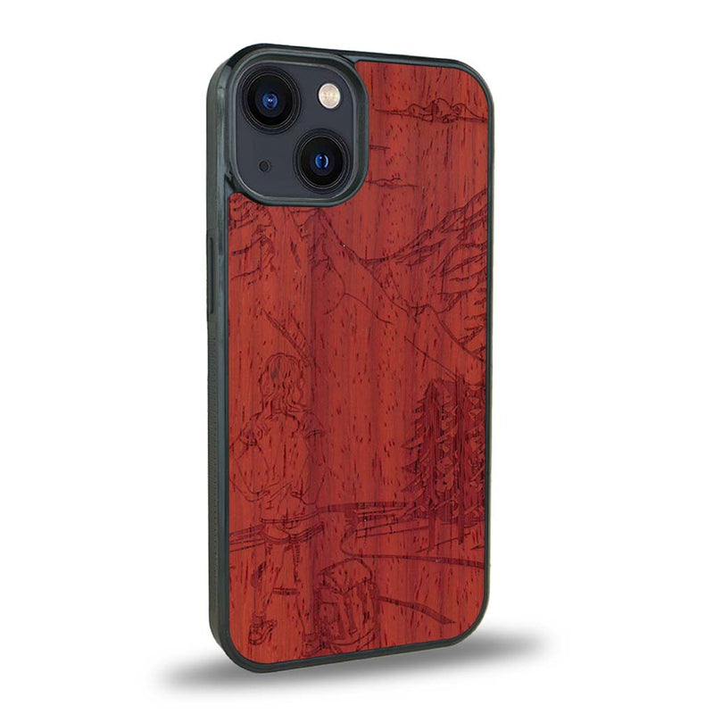 Coque de protection en bois véritable fabriquée en France pour iPhone 15 sur le thème de la randonnée en montagne et de l'aventure avec une gravure représentant une femme de dos face à un paysage de nature