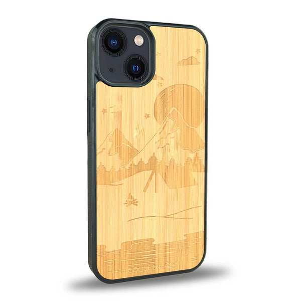 Coque de protection en bois véritable fabriquée en France pour iPhone 15 Plus sur le thème du camping en pleine nature représentant une tente avec un feu de camp entouré de montagnes