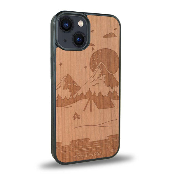 Coque de protection en bois véritable fabriquée en France pour iPhone 15 Plus sur le thème du camping en pleine nature représentant une tente avec un feu de camp entouré de montagnes