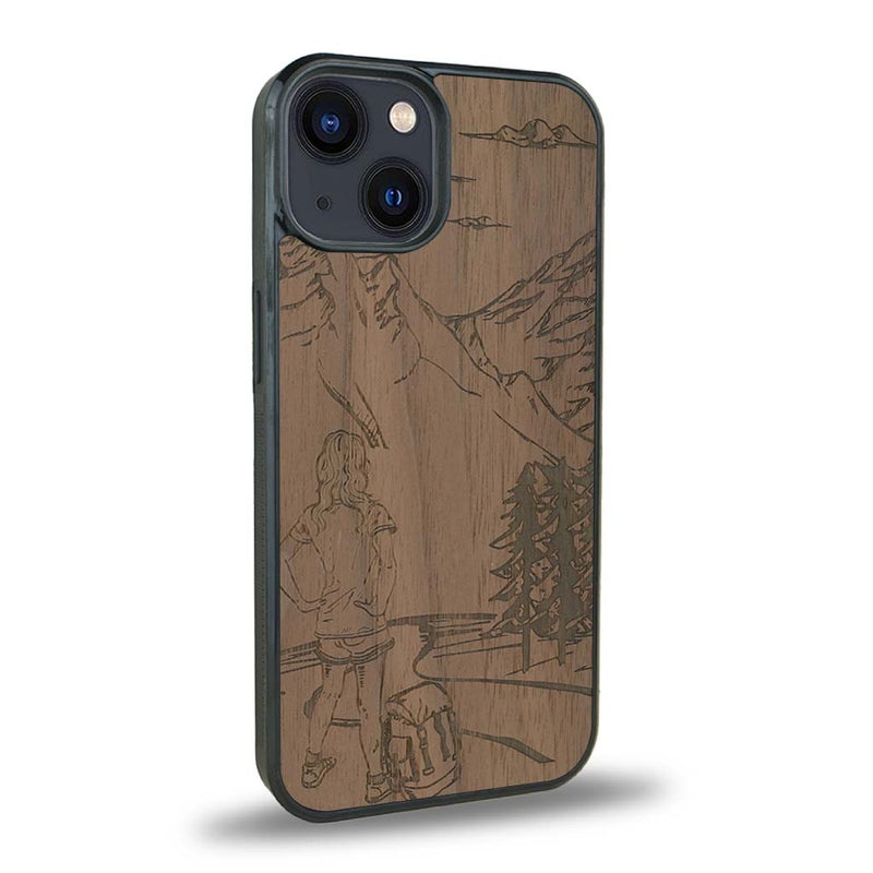 Coque de protection en bois véritable fabriquée en France pour iPhone 15 Plus + MagSafe® sur le thème de la randonnée en montagne et de l'aventure avec une gravure représentant une femme de dos face à un paysage de nature