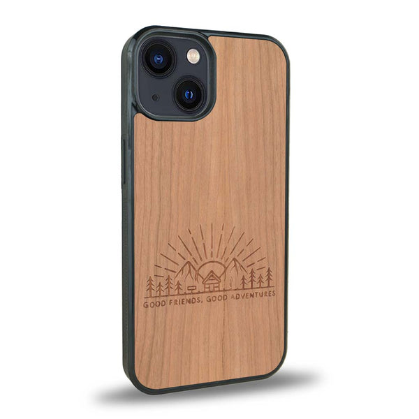 Coque de protection en bois véritable fabriquée en France pour iPhone 15 Plus sur le thème chill et nature avec un motif représentant un levé de soleil sur un paysage de montagne avec des sapins et un chalet et la phrase "Good friends, good adventure"