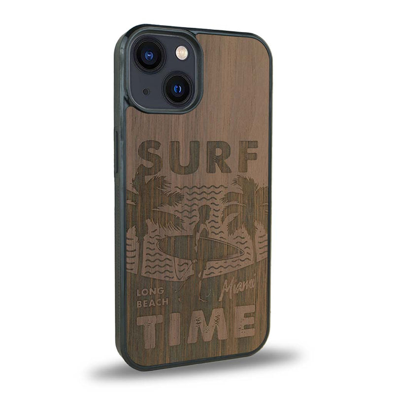 Coque de protection en bois véritable fabriquée en France pour iPhone 15 Plus sur le thème chill avec un motif représentant une silouhette tenant une planche de surf sur une plage entouré de palmiers et les mots "Surf Time Long Beach Miami"