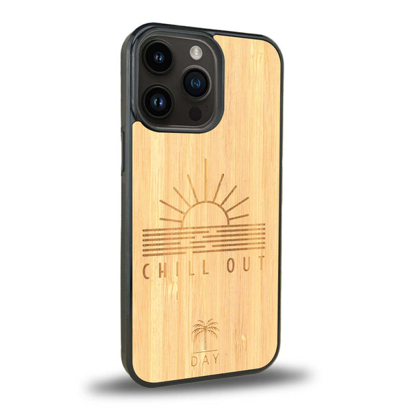 Coque de protection en bois véritable fabriquée en France pour iPhone 15 Pro sur le thème chill avec un motif représentant un couché de soleil sur l'océan et la phrase "Chill out"