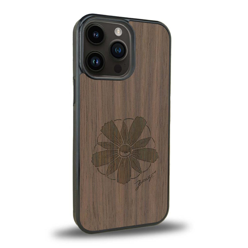 Coque de protection en bois véritable fabriquée en France pour iPhone 15 Pro sur le thème des fleurs et de la montagne avec un motif de gravure représentant les pétales d'une fleur des montagnes