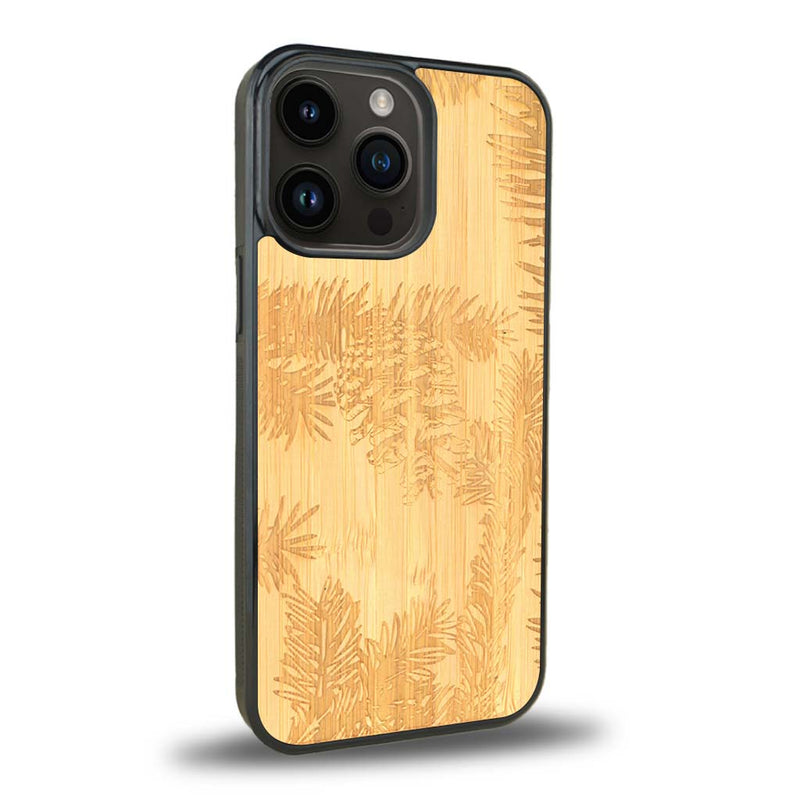 Coque de protection en bois véritable fabriquée en France pour iPhone 15 Pro sur le thème de la nature des arbres avec un motif de gravure représentant des épines de sapin et des pommes de pin