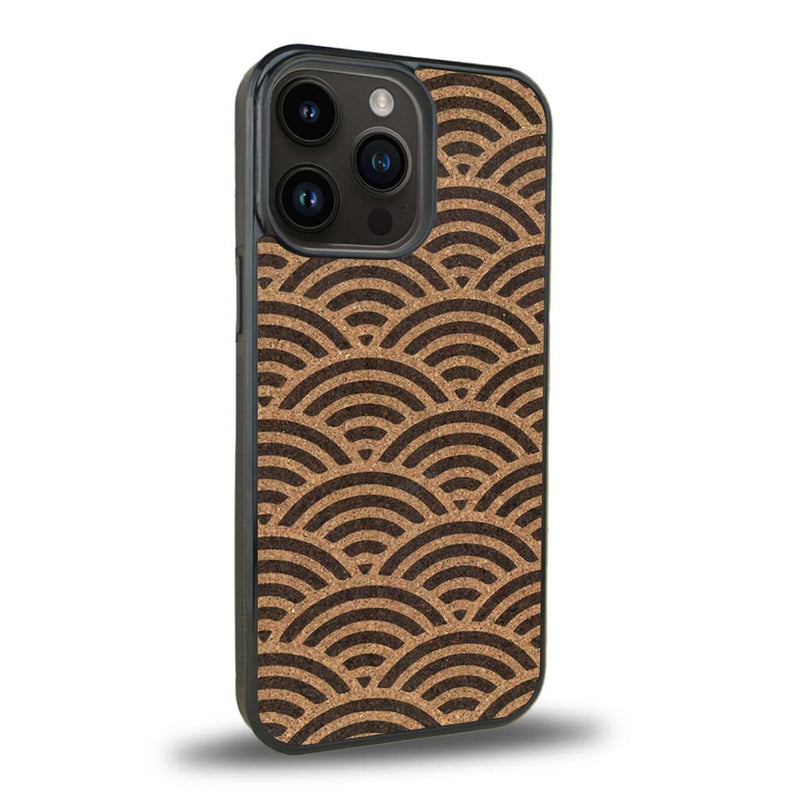 Coque de protection en bois véritable fabriquée en France pour iPhone 15 Pro baptisée "La Sinjak" avec un motif de gravure abstrait représentant la répétition d'un symbole wifi