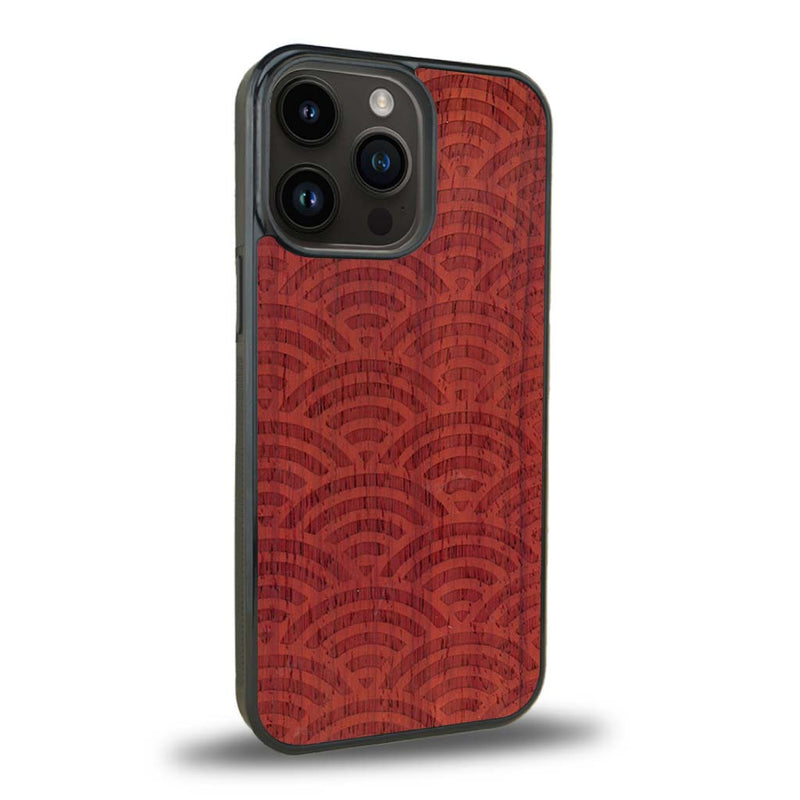 Coque de protection en bois véritable fabriquée en France pour iPhone 15 Pro baptisée "La Sinjak" avec un motif de gravure abstrait représentant la répétition d'un symbole wifi