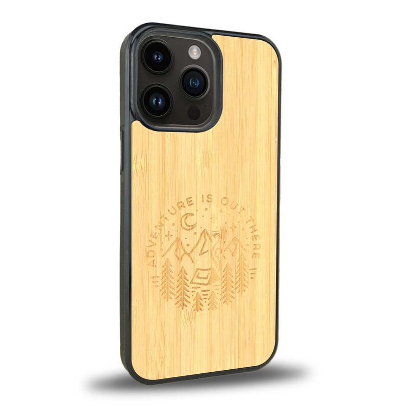 Coque de protection en bois véritable fabriquée en France pour iPhone 15 Pro sur le thème du camping en pleine nature et du bivouac avec la phrase "Aventure is out there"