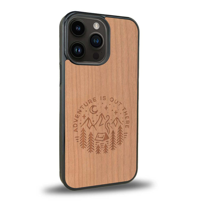 Coque de protection en bois véritable fabriquée en France pour iPhone 15 Pro sur le thème du camping en pleine nature et du bivouac avec la phrase "Aventure is out there"