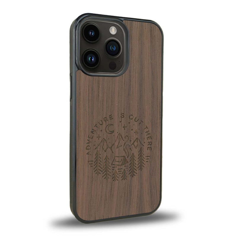 Coque de protection en bois véritable fabriquée en France pour iPhone 15 Pro sur le thème du camping en pleine nature et du bivouac avec la phrase "Aventure is out there"