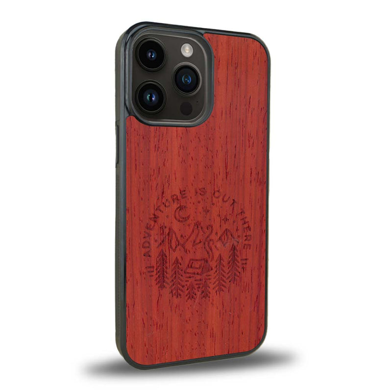 Coque de protection en bois véritable fabriquée en France pour iPhone 15 Pro sur le thème du camping en pleine nature et du bivouac avec la phrase "Aventure is out there"