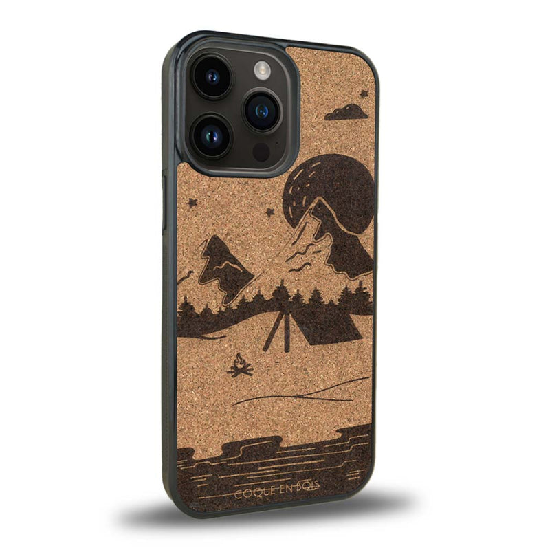 Coque de protection en bois véritable fabriquée en France pour iPhone 15 Pro sur le thème du camping en pleine nature représentant une tente avec un feu de camp entouré de montagnes