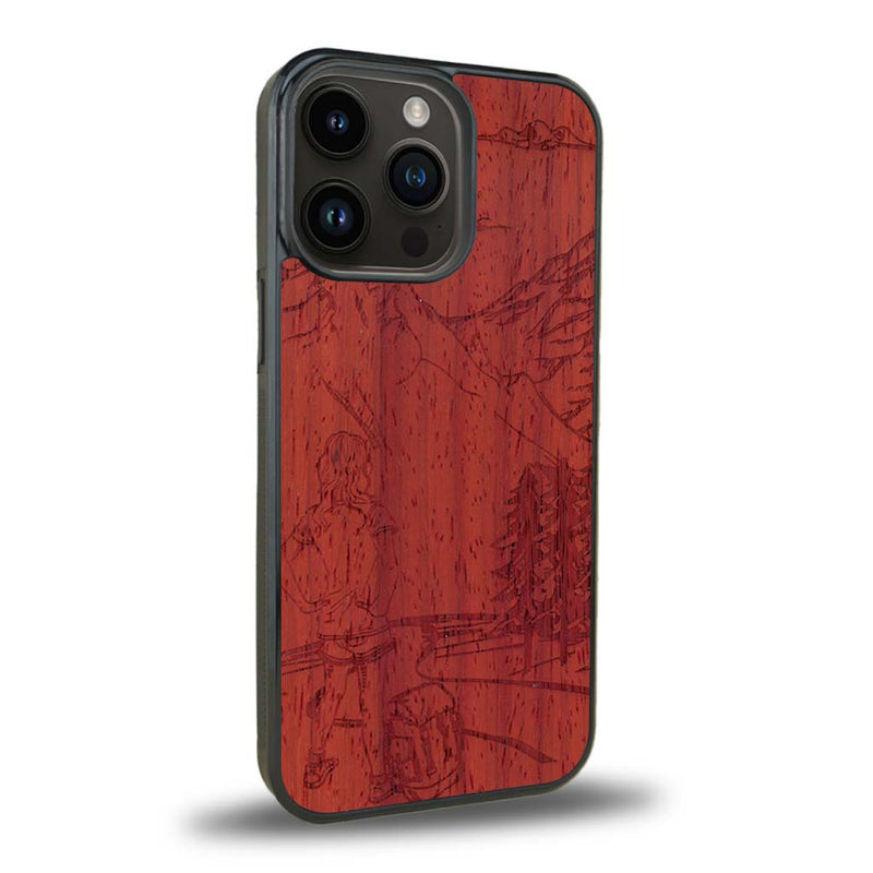 Coque de protection en bois véritable fabriquée en France pour iPhone 15 Pro sur le thème de la randonnée en montagne et de l'aventure avec une gravure représentant une femme de dos face à un paysage de nature