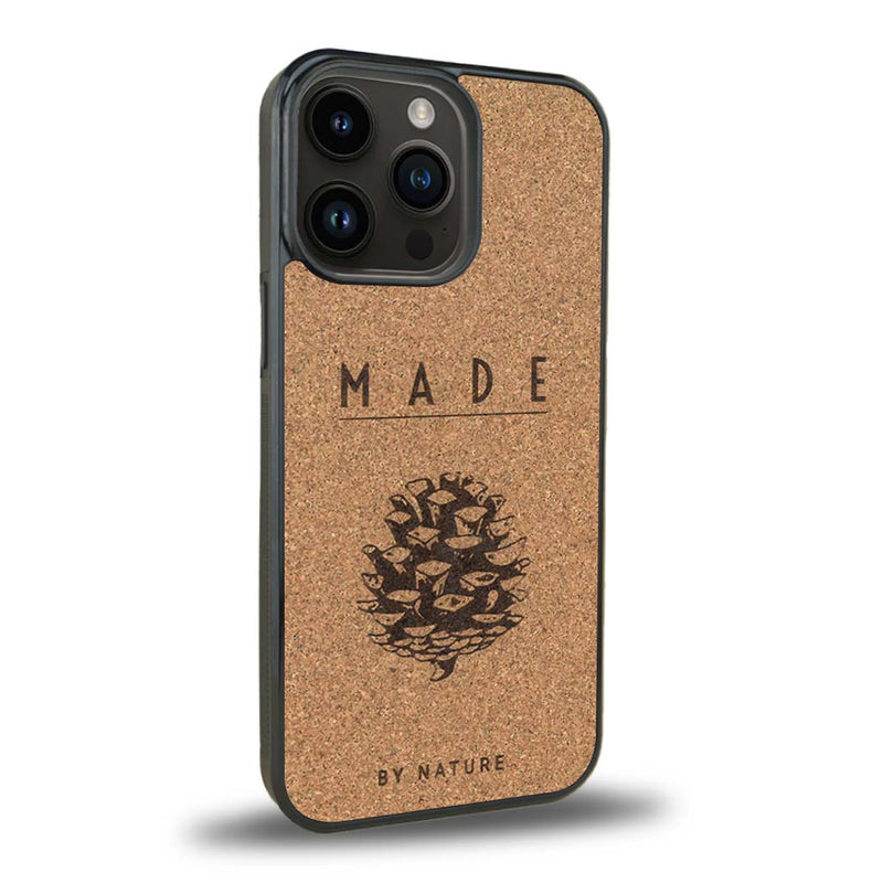 Coque de protection en bois véritable fabriquée en France pour iPhone 15 Pro sur le thème de la nature et des arbres avec une gravure représentant une pomme de pin et la phrase "made by nature"