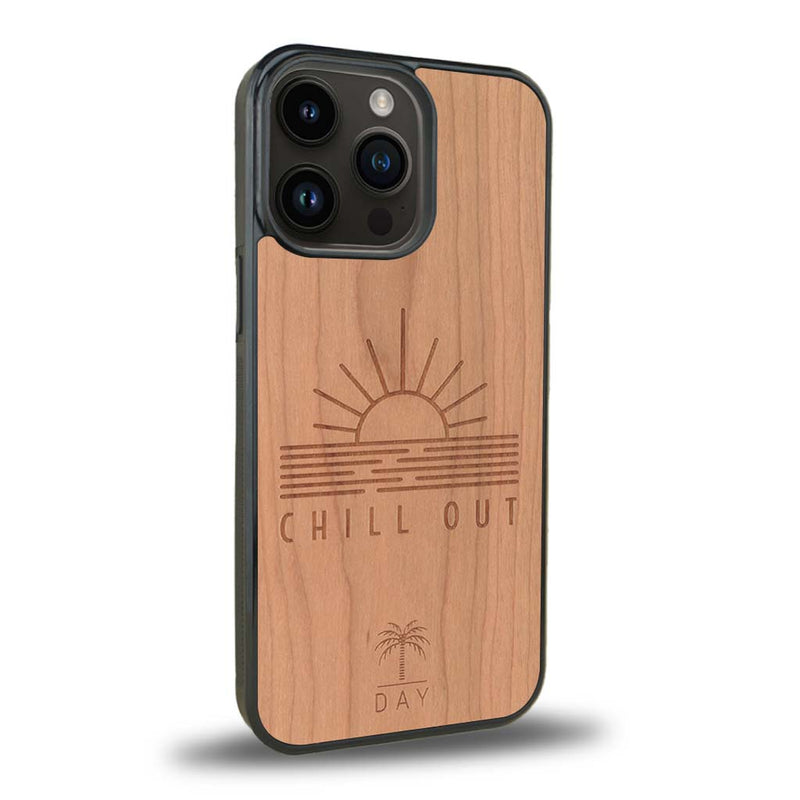 Coque de protection en bois véritable fabriquée en France pour iPhone 15 Pro Max sur le thème chill avec un motif représentant un couché de soleil sur l'océan et la phrase "Chill out"