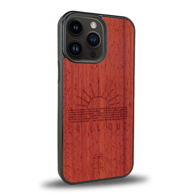 Coque de protection en bois véritable fabriquée en France pour iPhone 15 Pro Max sur le thème chill avec un motif représentant un couché de soleil sur l'océan et la phrase "Chill out"