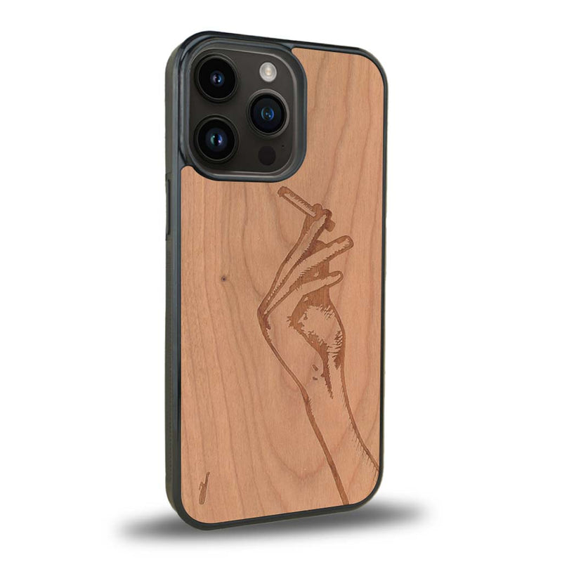 Coque de protection en bois véritable fabriquée en France pour iPhone 15 Pro Max représentant une main de femme tenant une cigarette de type line art en collaboration avec l'artiste Maud Dabs