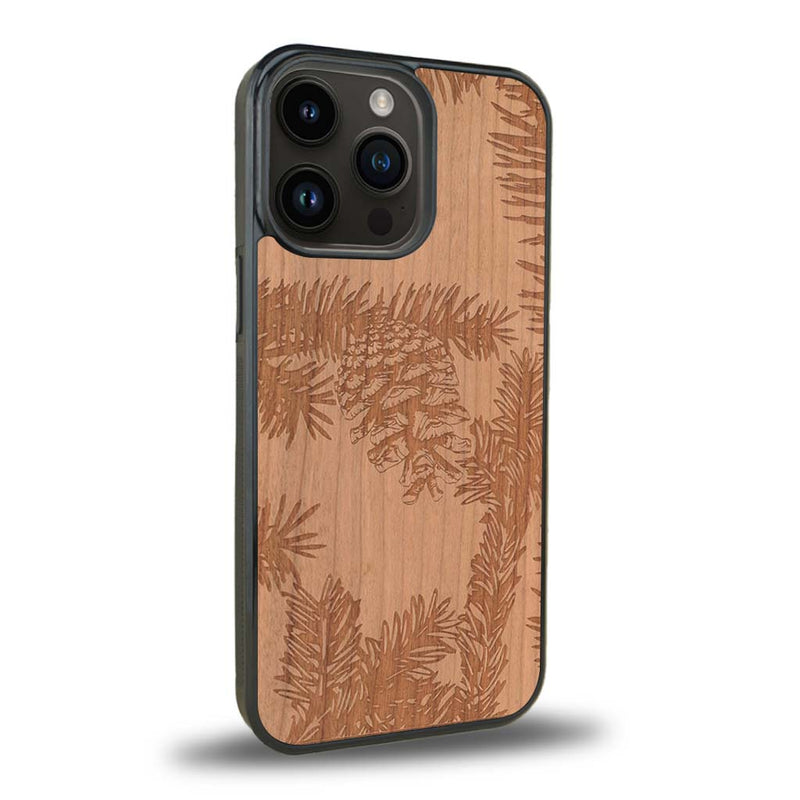 Coque de protection en bois véritable fabriquée en France pour iPhone 15 Pro Max sur le thème de la nature des arbres avec un motif de gravure représentant des épines de sapin et des pommes de pin