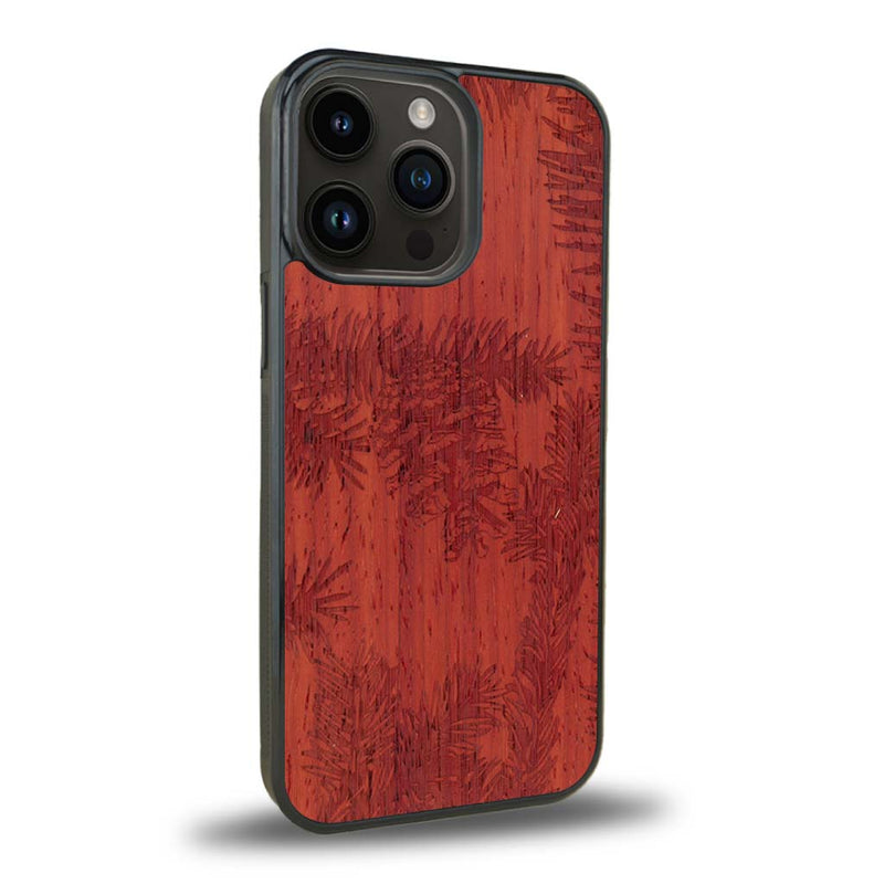 Coque de protection en bois véritable fabriquée en France pour iPhone 15 Pro Max sur le thème de la nature des arbres avec un motif de gravure représentant des épines de sapin et des pommes de pin