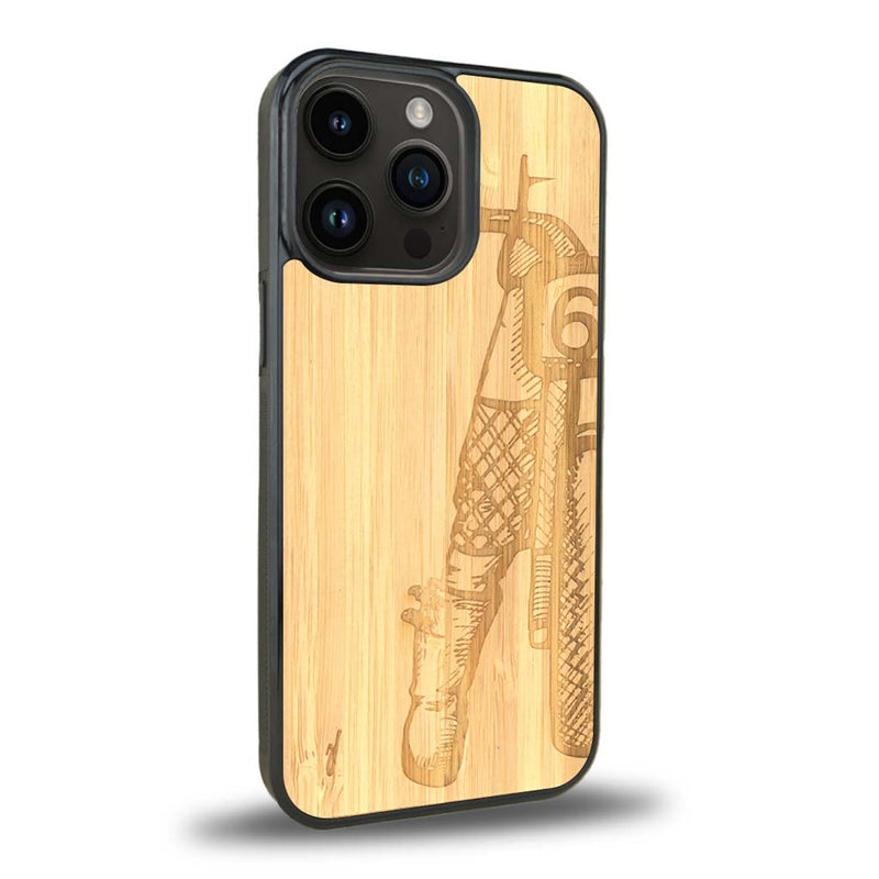 Coque de protection en bois véritable fabriquée en France pour iPhone 15 Pro Max représentant une vue de face d'une femme sur une moto vintage dessinée à la main par l'artiste Maud Dabs