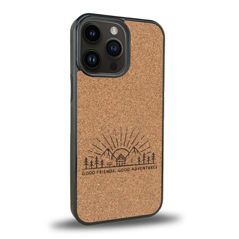 Coque de protection en bois véritable fabriquée en France pour iPhone 15 Pro Max sur le thème chill et nature avec un motif représentant un levé de soleil sur un paysage de montagne avec des sapins et un chalet et la phrase "Good friends, good adventure"