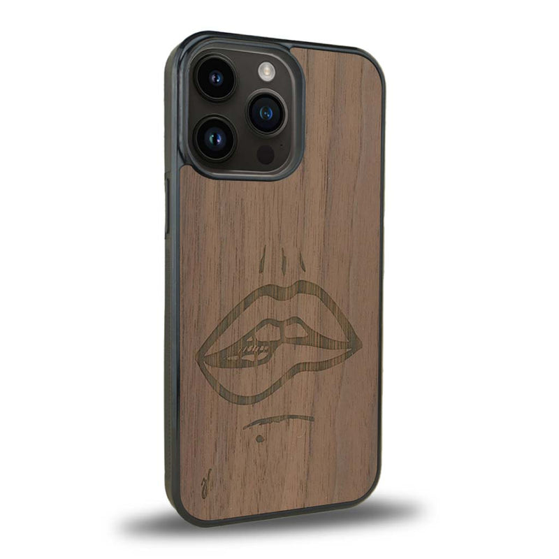 Coque de protection en bois véritable fabriquée en France pour iPhone 15 Pro Max représentant de manière minimaliste une bouche de féminine se mordant le coin de la lèvre de manière sensuelle dessinée à la main par l'artiste Maud Dabs