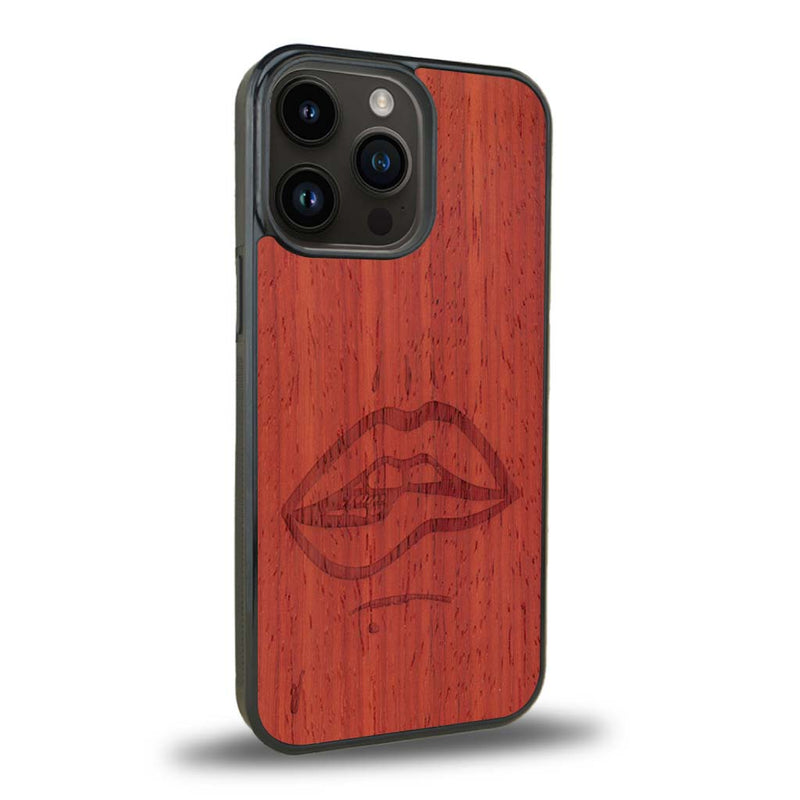 Coque de protection en bois véritable fabriquée en France pour iPhone 15 Pro représentant de manière minimaliste une bouche de féminine se mordant le coin de la lèvre de manière sensuelle dessinée à la main par l'artiste Maud Dabs